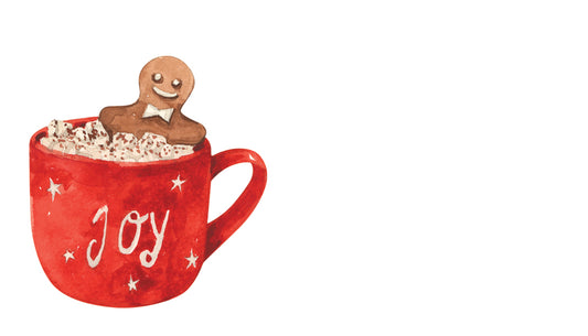 Red mug with 'JOY' text, filled with hot chocolate and a gingerbread man decoration on a white background